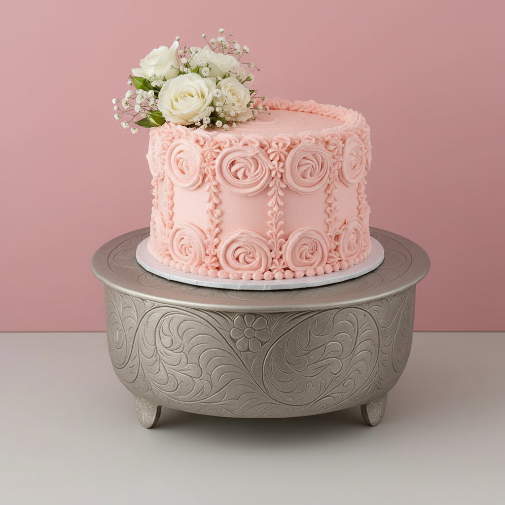 Decorative metal box with intricate patterns on a pink background